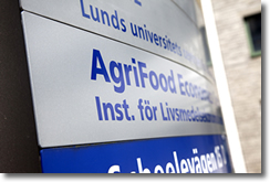 En skylt där det står 'AgriFood Economics Centre', placerad utanför AgriFoods kontorsbyggnad. Foto.